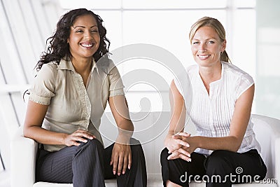 Businesswomen sitting in lobby Stock Photo