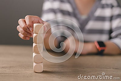 Businesswomen stack blank wooden cubes on the table with copy space, empty wooden cubes for input wording, and an infographic icon Stock Photo