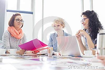 Businesswomen working at desk in creative office Stock Photo