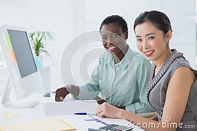 Businesswomen working together at desk Stock Photo