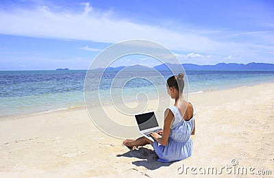 Bussines woman working on the beach with a laptop Stock Photo