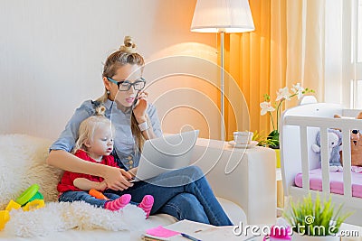 Mom with toddler working on laptop Stock Photo