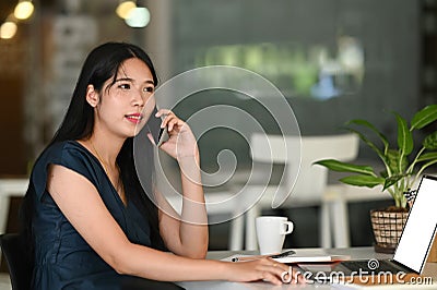 Bussinesswoman talking customer with smartphone about her project recive order using laptop computer. Stock Photo