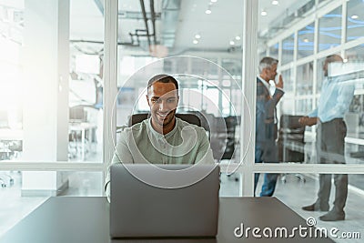 Busy african businessman workingon laptop while sitting in modern coworking Stock Photo
