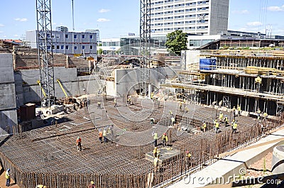 Busy construction site, with workers and heavy machinery Editorial Stock Photo