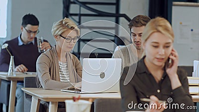 Busy design office with workers at desks Stock Photo