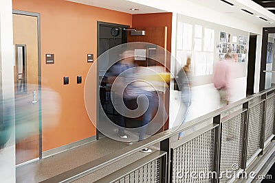 Busy High School Corridor During Recess With Blurred Students And Staff Stock Photo