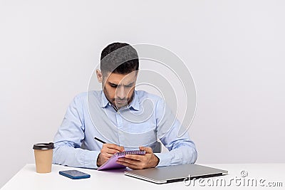 Busy inspired man employee writing creative idea paper notebook, preparing report doing paperwork Stock Photo