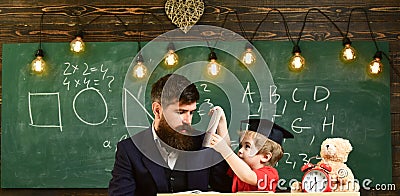 Busy kid studying at school. Father checking homework, helps to boy, son. Individual studying concept. Teacher in formal Stock Photo