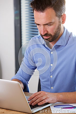 Busy mature man working on laptop at his desk Stock Photo