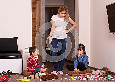 Busy mom. Mom tired to tidy up the house. Child scattered toys. Mess in the house. Stock Photo