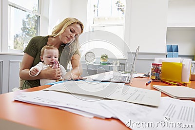 Busy Mother With Baby Running Business From Home Stock Photo