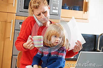Busy Mother Coping With Stressful Day At Home Stock Photo