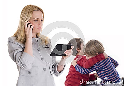 Busy mother with tablet and mobile while her children fighting Stock Photo