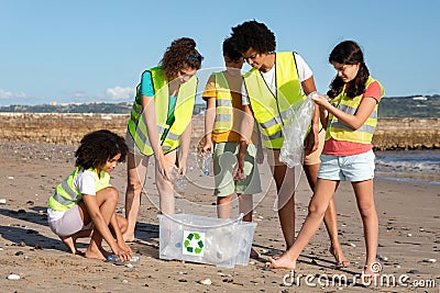 Busy positive international teenager schoolchildren volunteers in uniform collect garbage and plastic bottles Stock Photo