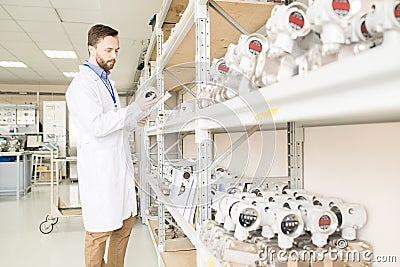 Busy quality control engineer examining manometers in warehouse Stock Photo