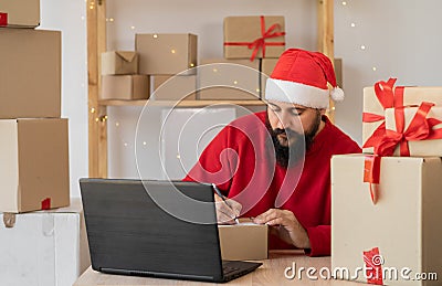busy Santa Clause packing gift boxes preparing fast xmas delivery. funny Santa in workshop warehouse in Merry Christmas Stock Photo