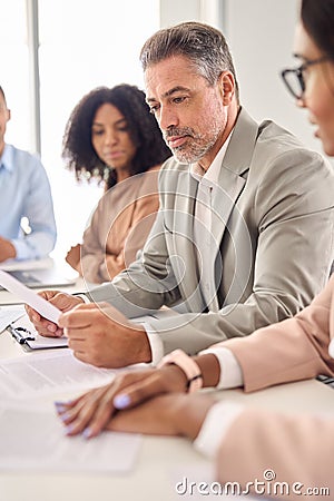 Busy senior Indian businessman investor reading law document at office meeting. Stock Photo