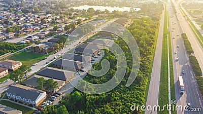 Busy traffic on Interstate 10 highway near Lake Barrington early morning along row of townhouses, condos, lush green trees and Stock Photo
