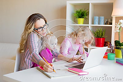 Busy woman trying to work while babysitting two kids Stock Photo