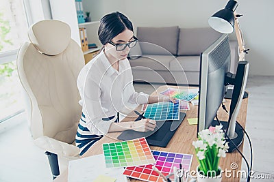 Busy young asian graphic designer is drawing something on graphic tablet at the office, focused. She is a successful self Stock Photo