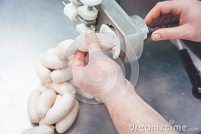 Butcher in butchery filling sausages Stock Photo