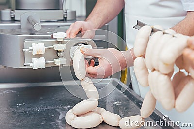 Butcher in butchery filling sausages Stock Photo