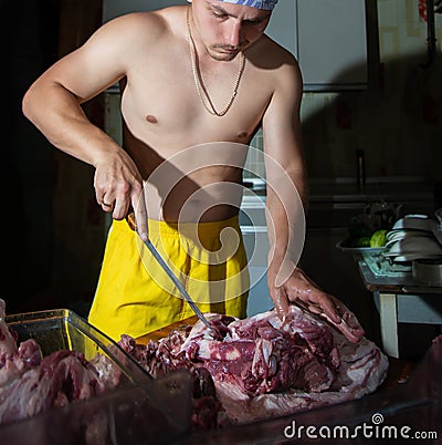 Butcher cutting pork meat on kitchen, chef cutting fresh raw meat on table Stock Photo