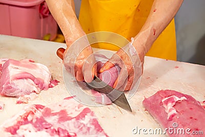 Butcher hands cutting slices of raw meat at market Stock Photo
