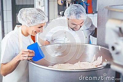 Butcher man and woman working together mincing meat Stock Photo