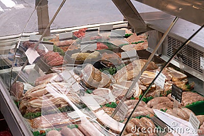 At the butcher shop, you can see a range of fresh meats and products in the refrigerated display. The shop is called Ledbury DT Editorial Stock Photo