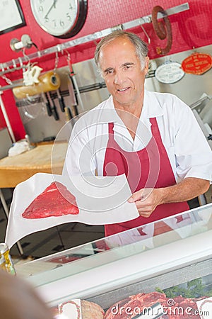 Butcher showing steak to customer Stock Photo