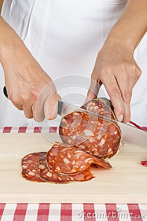 Butcher slicing a Spanish sausage called morcon Stock Photo