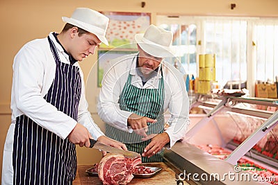 Butcher Teaching Apprentice How To Prepare Meat Stock Photo