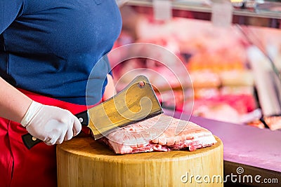 Butcher woman chopping meat on a block Stock Photo