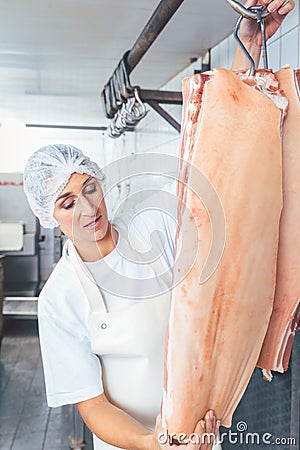 Butcher woman cutting meat for further use Stock Photo