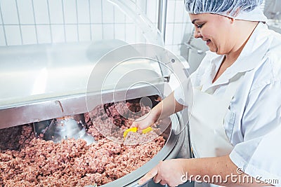 Butcher woman working on meat in butchery Stock Photo