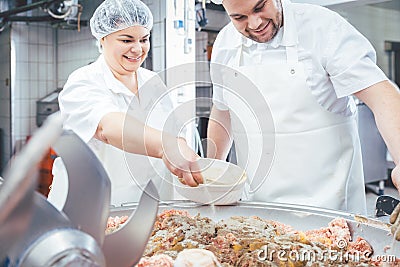 Butchers putting spices in minced meat Stock Photo