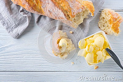 Butter and fresh crunchy homemade bread. Healthy organic breakfast on rustic white wooden table Stock Photo