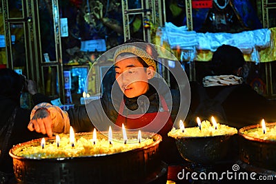 Butter lamps and Tibetan famale Editorial Stock Photo