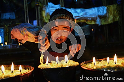 Butter lamps and Tibetan famale Editorial Stock Photo