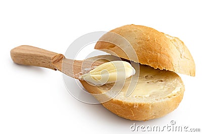 Butter spread on a cut crusty bread roll with a wooden knife iso Stock Photo