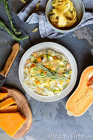 Butter squash pasta salad with zucchini slices, cheddar cheese and scallion Stock Photo