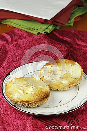 Buttered Everything Bagel on a Plate over a Placemat Stock Photo