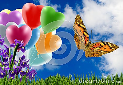 butterfly, grass, flowers and colorful balloons against a sky with clouds Stock Photo