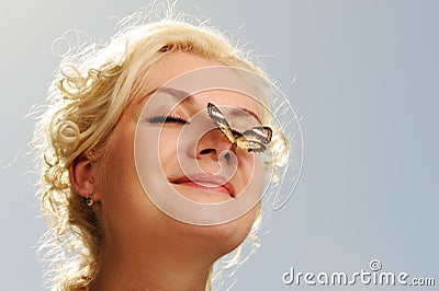 Butterfly sitting on a woman nose Stock Photo