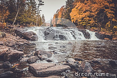 Buttermilk Falls surrounded by brilliant fall foliage in Long Lake NY, ADK Mountains Stock Photo