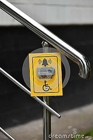 Button for calling help for disabled on handrail of the stairs, Russia Stock Photo