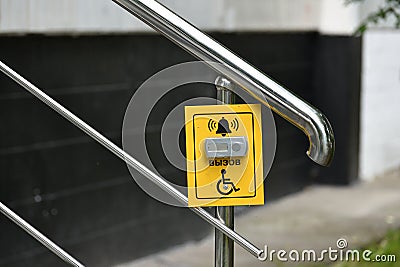 Button for calling help for disabled on handrail of the stairs, Russia Stock Photo