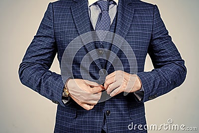 Buttoning up male vested blue suit with tie in formal fashion style grey background, formalwear Stock Photo